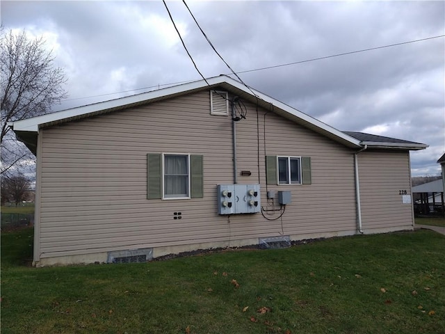 view of side of home with a yard