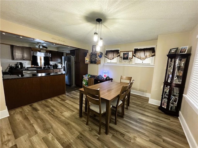 dining space featuring dark hardwood / wood-style floors and a textured ceiling