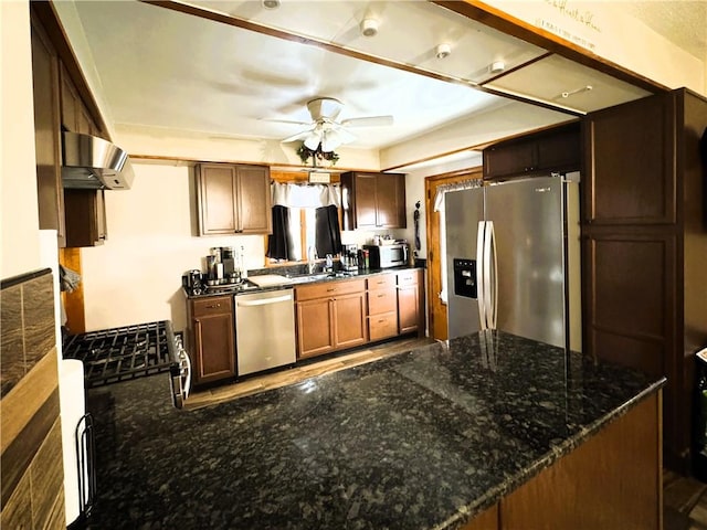 kitchen with sink, extractor fan, kitchen peninsula, ceiling fan, and stainless steel appliances