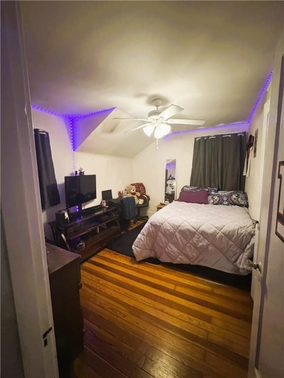 bedroom featuring ceiling fan, wood-type flooring, and vaulted ceiling