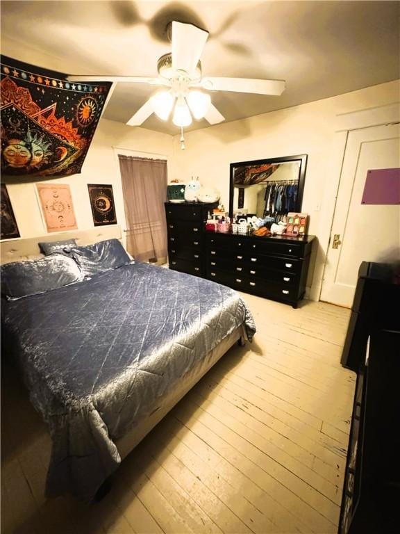 bedroom with wood-type flooring and ceiling fan