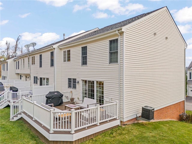 rear view of property featuring a wooden deck, central AC unit, and a lawn