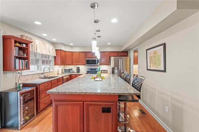 kitchen with a breakfast bar, stainless steel appliances, a center island, and sink