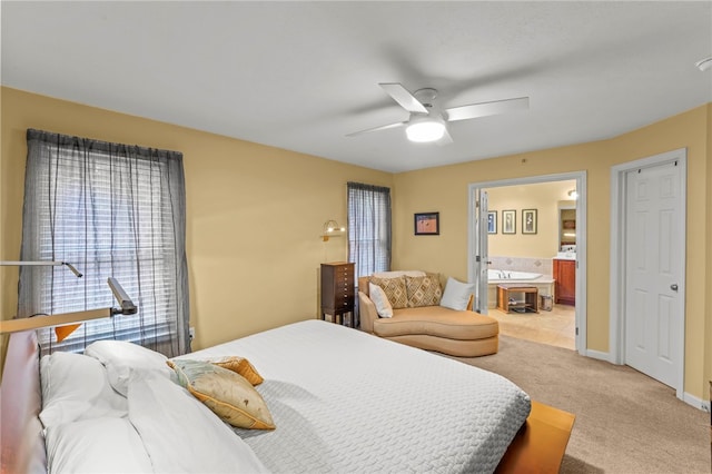 carpeted bedroom with ensuite bathroom and ceiling fan