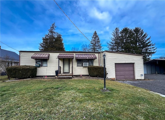 ranch-style home with a garage, a carport, a front yard, and cooling unit