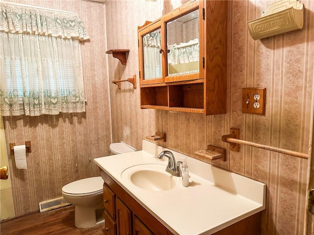 bathroom featuring vanity, hardwood / wood-style flooring, and toilet