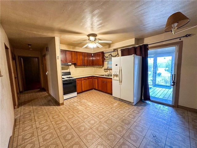 kitchen with sink, white appliances, a textured ceiling, and ceiling fan