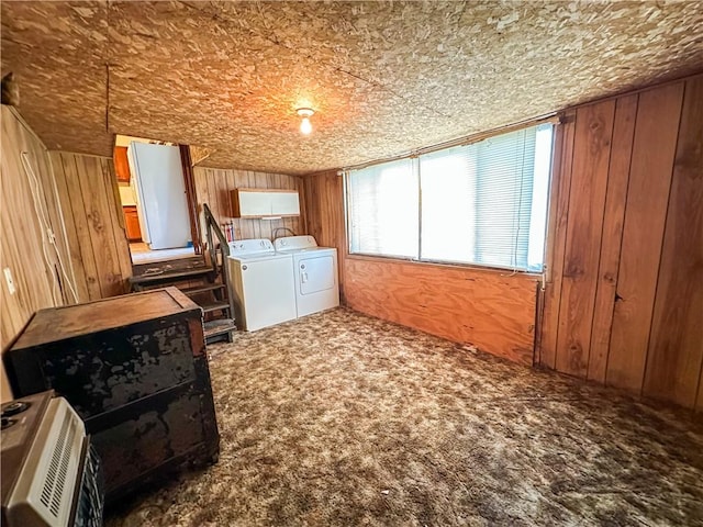 washroom with cabinets, washer and clothes dryer, wooden walls, and carpet