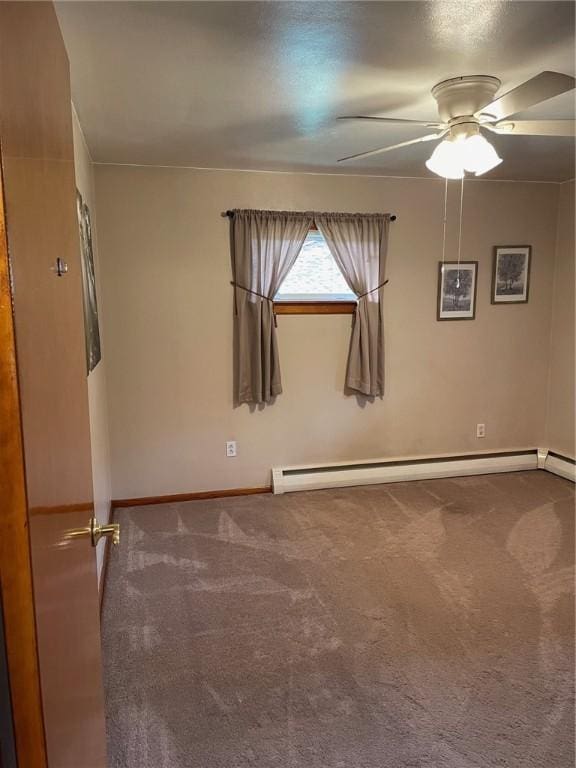 spare room featuring ceiling fan, carpet, and a baseboard heating unit