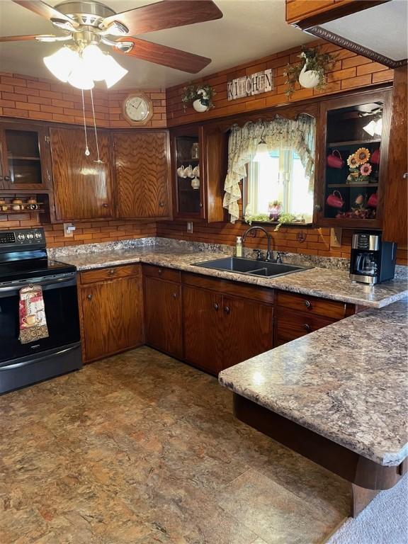 kitchen with black / electric stove, ceiling fan, kitchen peninsula, and sink