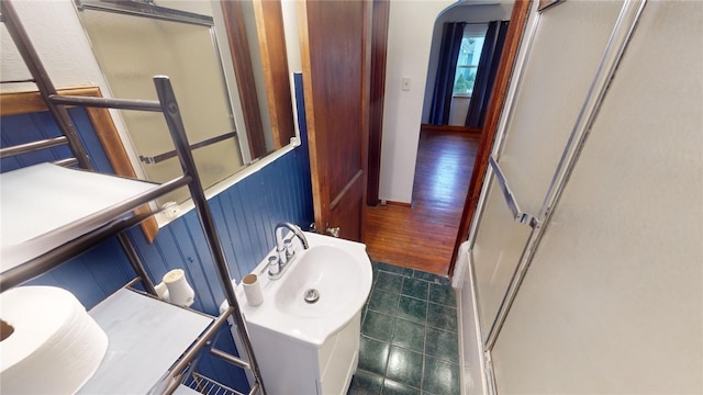 bathroom featuring a shower with door, sink, and hardwood / wood-style floors