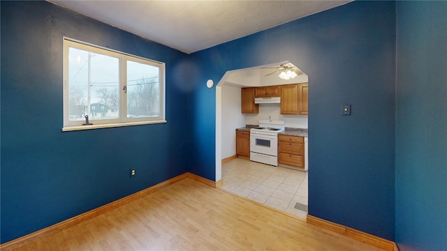 kitchen featuring white gas range, ceiling fan, and light hardwood / wood-style flooring