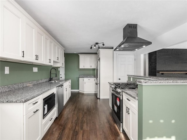 kitchen with appliances with stainless steel finishes, white cabinetry, sink, dark hardwood / wood-style flooring, and island exhaust hood