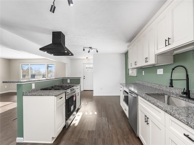 kitchen with sink, island range hood, white cabinets, and appliances with stainless steel finishes