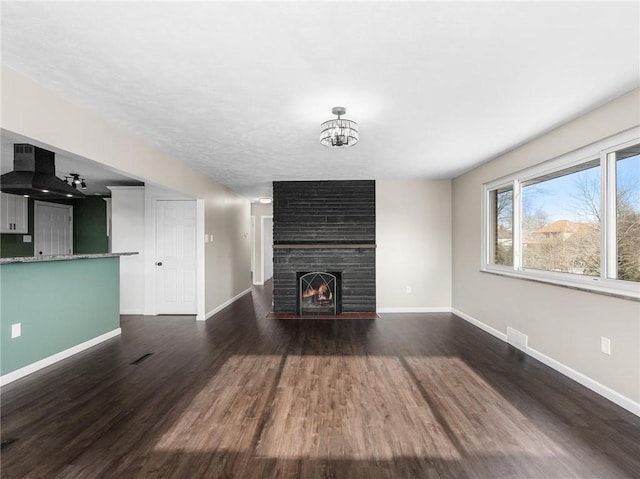 unfurnished living room with dark wood-type flooring and a large fireplace