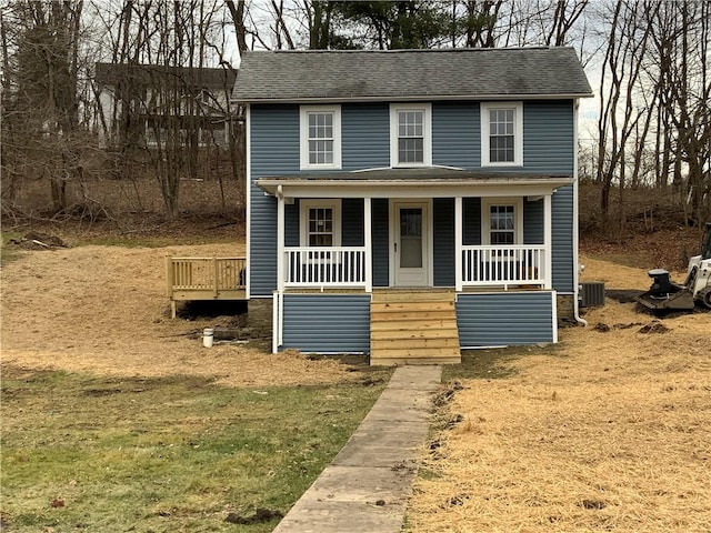 view of front of house featuring central AC, a front lawn, and covered porch