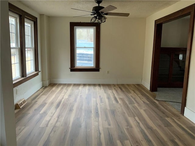 spare room with ceiling fan, wood-type flooring, and a textured ceiling