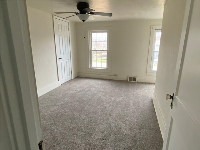 unfurnished room with a healthy amount of sunlight, carpet flooring, and ceiling fan