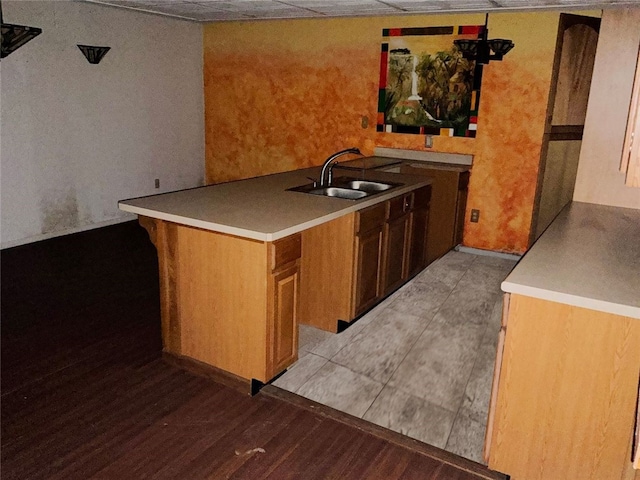 kitchen with sink, kitchen peninsula, and light wood-type flooring