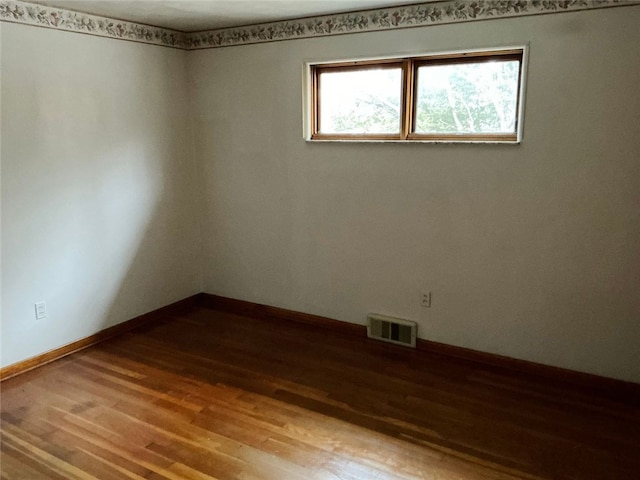 spare room with wood-type flooring