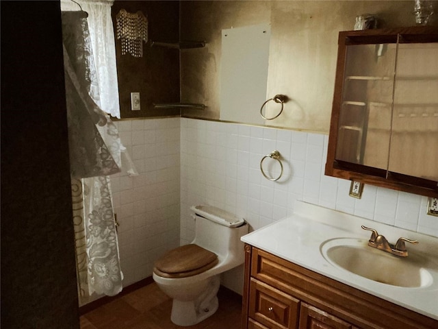 bathroom featuring vanity, tile walls, and toilet