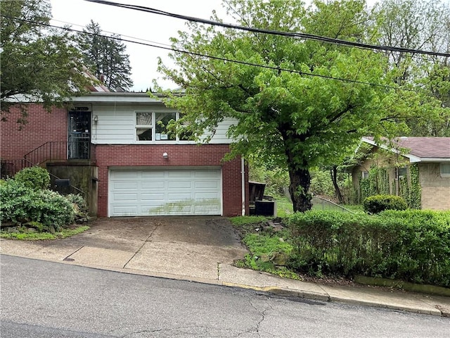 125 Webster St, Rochester Twp, PA 15074 - view of front facade with brick siding, concrete driveway, a garage, and central AC