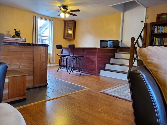 bar with hardwood / wood-style flooring and ceiling fan