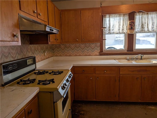 kitchen with tasteful backsplash, sink, and white gas stove