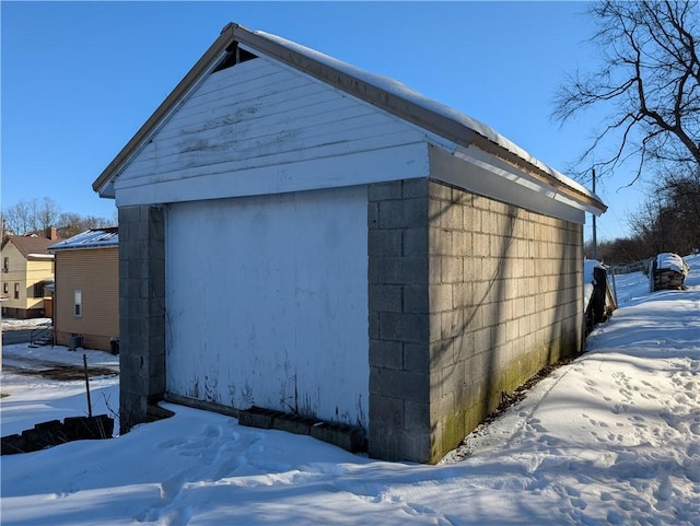 snow covered structure with a garage