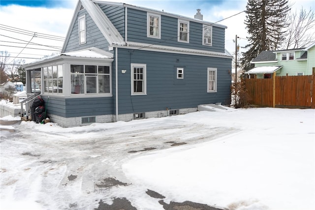 snow covered property featuring a sunroom