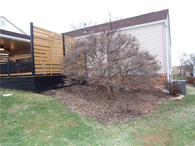 view of side of property with a lawn and central air condition unit