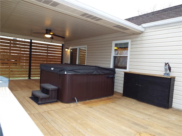 wooden deck with ceiling fan and a hot tub