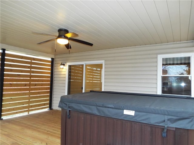 view of patio with ceiling fan, a hot tub, and a deck