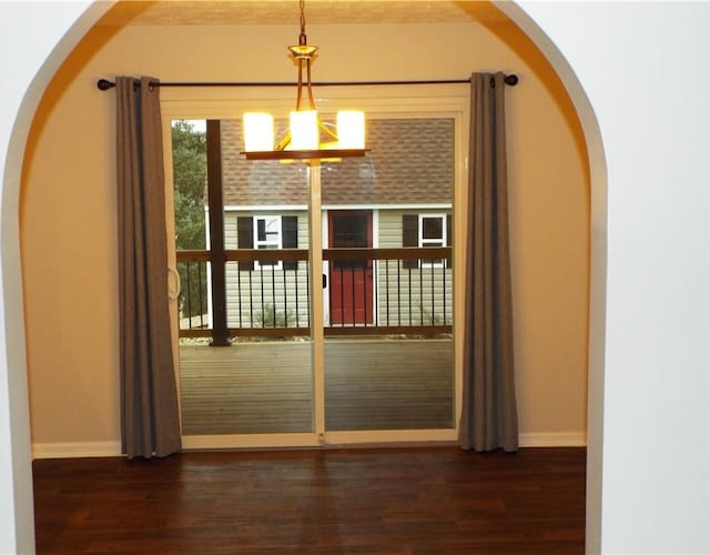 doorway to outside featuring a chandelier and dark hardwood / wood-style flooring