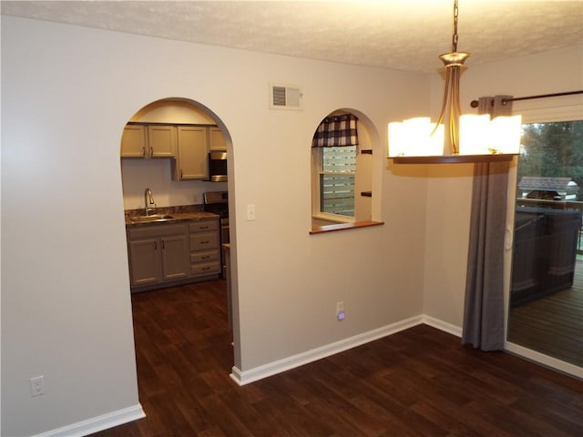 unfurnished dining area featuring dark hardwood / wood-style floors, sink, and a textured ceiling