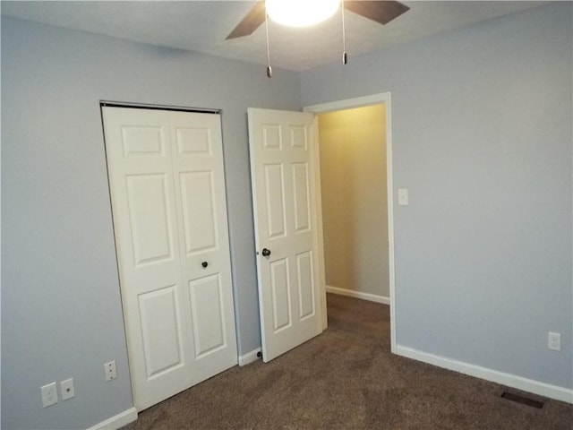 unfurnished bedroom with a closet, ceiling fan, and dark colored carpet