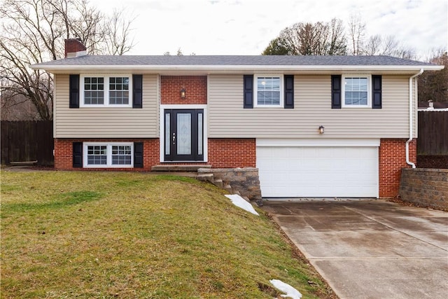 bi-level home featuring a garage and a front yard