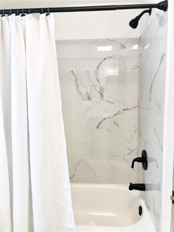 bathroom with shower / bath combo with shower curtain