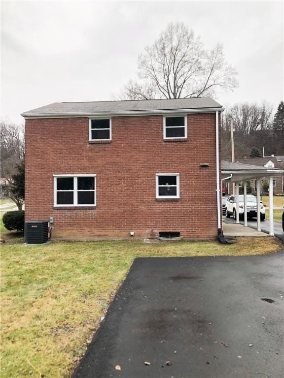 view of property exterior with a carport, a yard, and cooling unit