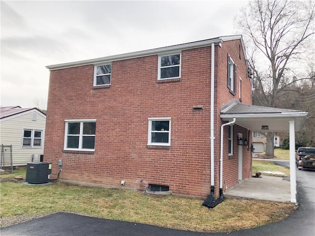 view of side of home with a carport and central AC unit