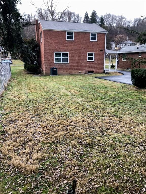 back of property featuring a yard and central AC unit