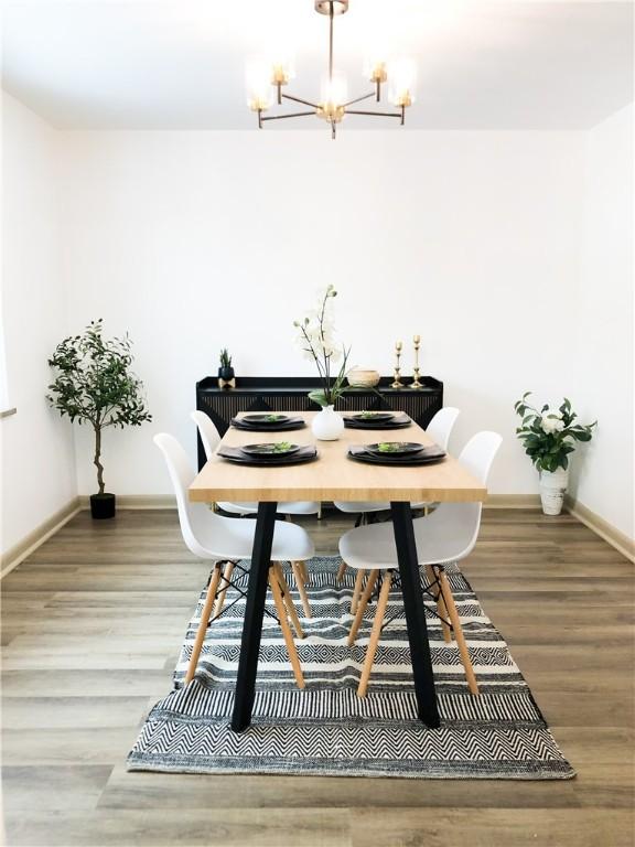 dining area with hardwood / wood-style flooring and a chandelier