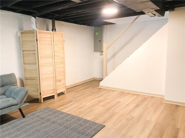 basement featuring hardwood / wood-style flooring and electric panel