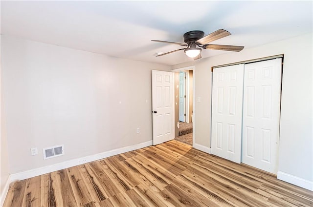 unfurnished bedroom with light hardwood / wood-style flooring, a closet, and ceiling fan