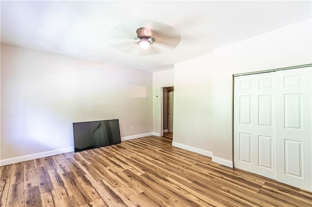 unfurnished bedroom with light hardwood / wood-style floors, a closet, and ceiling fan