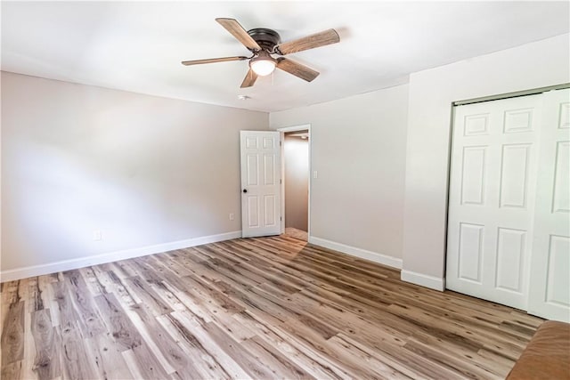 unfurnished bedroom with ceiling fan, a closet, and light wood-type flooring