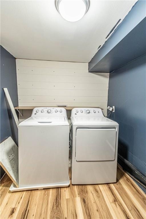 laundry room with separate washer and dryer and light wood-type flooring