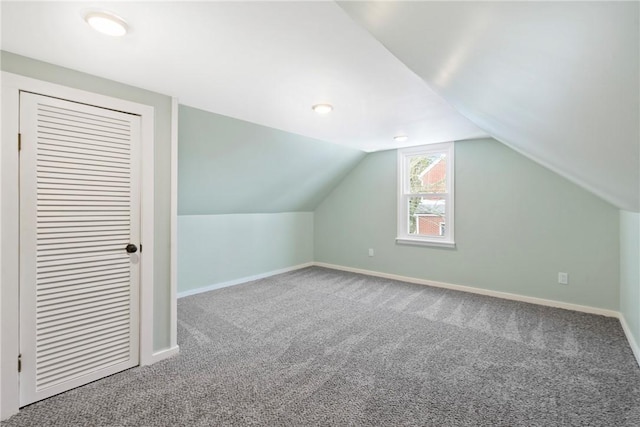 additional living space with lofted ceiling and carpet flooring