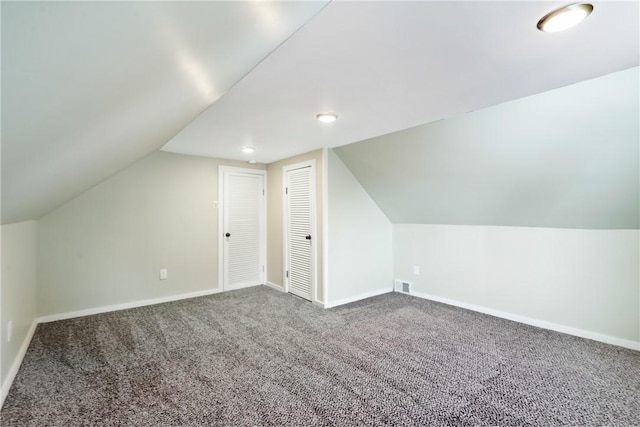 additional living space featuring vaulted ceiling and carpet