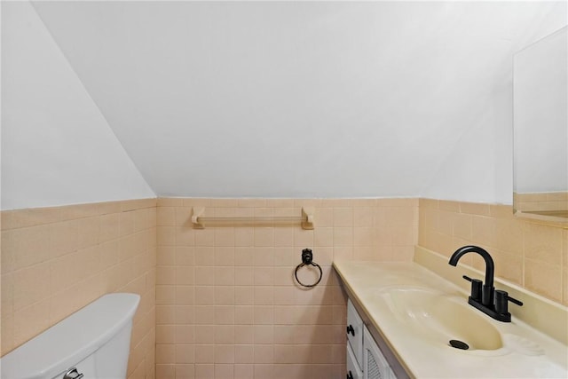 bathroom with vanity, tile walls, and toilet